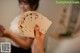 A woman holding a deck of playing cards in her hands.