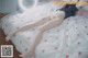 A woman laying on a bed with a teddy bear.