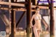 A woman in a white bikini standing on a pier.