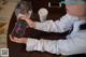 A woman sitting at a table with a cup of coffee and a phone.