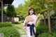 A woman in a pink kimono holding a fan.