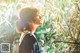 A woman standing in front of a bamboo tree.