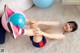 A young girl laying on the floor with a blue ball.