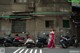 A woman in a long dress standing in front of parked motorcycles.