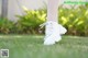 A close up of a person's feet in white shoes on the grass.